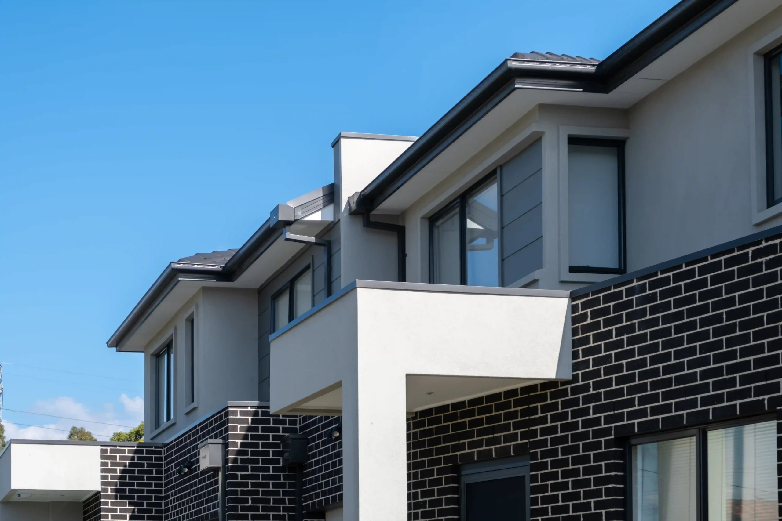 Exterior of modern residential townhouses painted by GoBrush Painting in Melbourne – Contemporary design with dark brick and light gray stucco